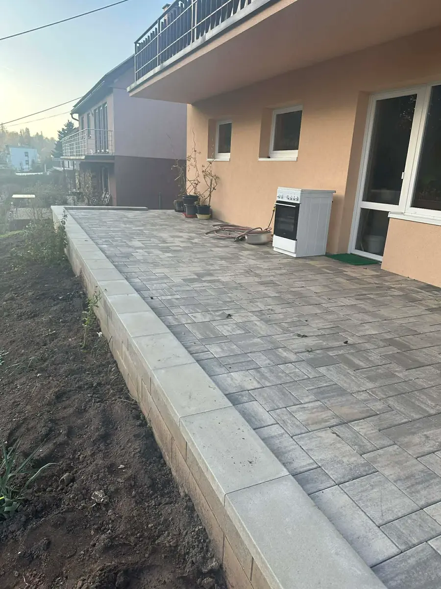 Zámková dlažba terasy podél opěrné zídky u rodinného domu